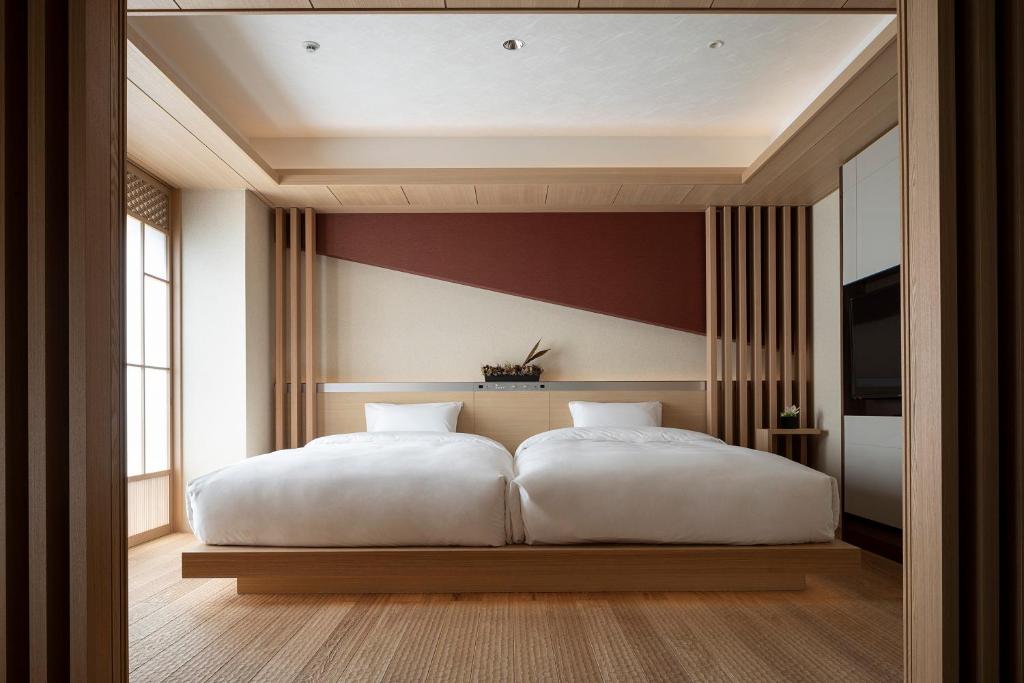 a bedroom with a large white bed in it at Cross Hotel Kyoto in Kyoto