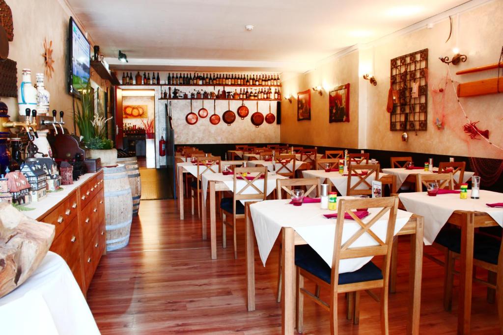 a restaurant with white tables and chairs in a room at Hotel Bahnhof Haus in Chiasso