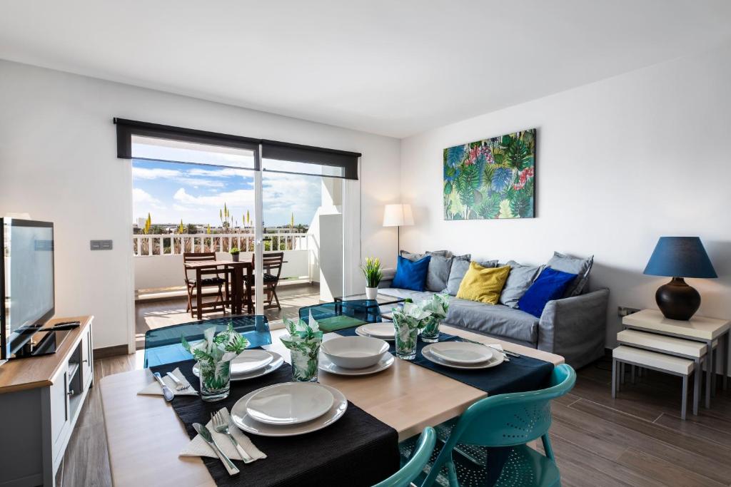 een keuken en een woonkamer met een tafel en stoelen bij The Colors House, 629 - Private Apartment in Costa Teguise