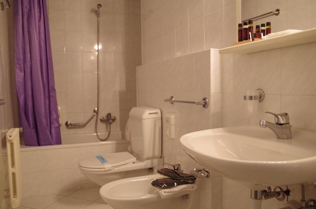a bathroom with a toilet and a sink at Hotel Bahnhof Haus in Chiasso