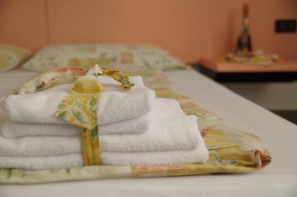 a pile of towels sitting on top of a bed at Hotel Bahnhof Haus in Chiasso