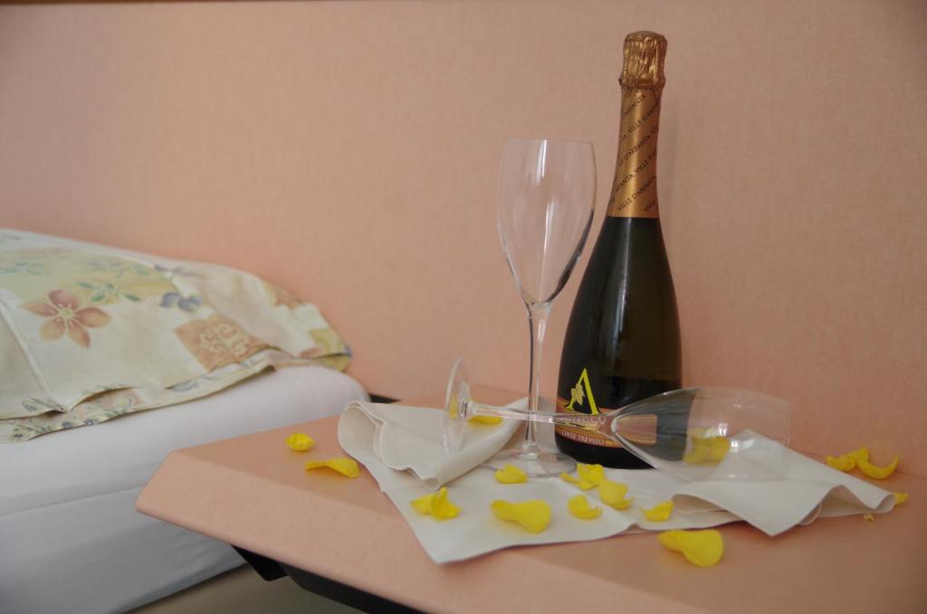 a table with a bottle of wine and a champagne glass at Hotel Bahnhof Haus in Chiasso