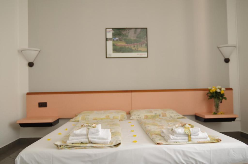 a bedroom with a bed with towels on it at Hotel Bahnhof Haus in Chiasso