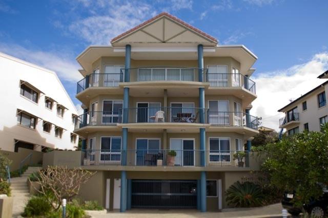 un gran edificio de apartamentos con columnas azules en Pacific Waves Apartments, en Noosa Heads