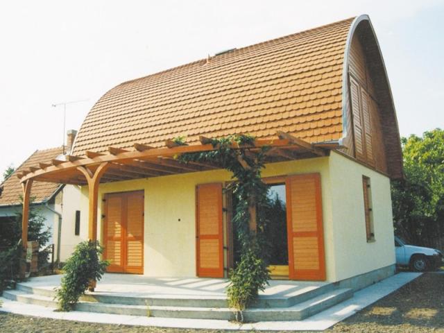 une petite maison avec un toit en gambrel dans l'établissement Gitta Nyaralohaz, à Gyomaendrőd