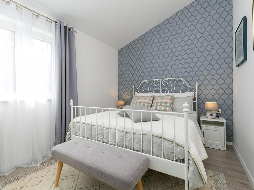 1 dormitorio con cama blanca y pared azul en Holiday Dream, en Vrsar