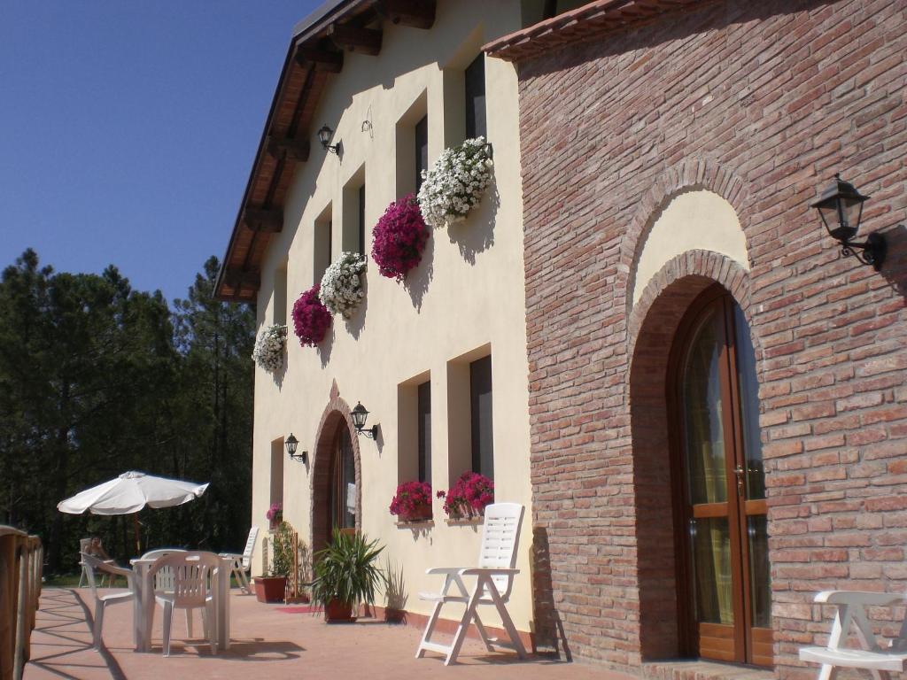 um edifício com flores ao lado em AGRITURISMO SANTA BARBARA COUNTRY HOUSE em San Miniato