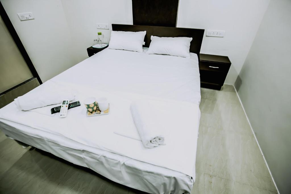 1 dormitorio con 1 cama blanca grande y 2 mesitas de noche en Indra Regency, en Tiruttani