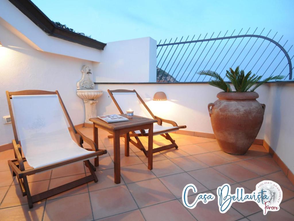 a balcony with two chairs and a table and a vase at Casa Bellavista in Furore