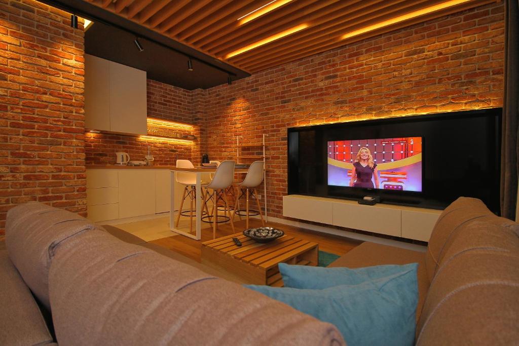 een woonkamer met een bank en een flatscreen-tv bij Elena Apartment&Spa in Zlatibor