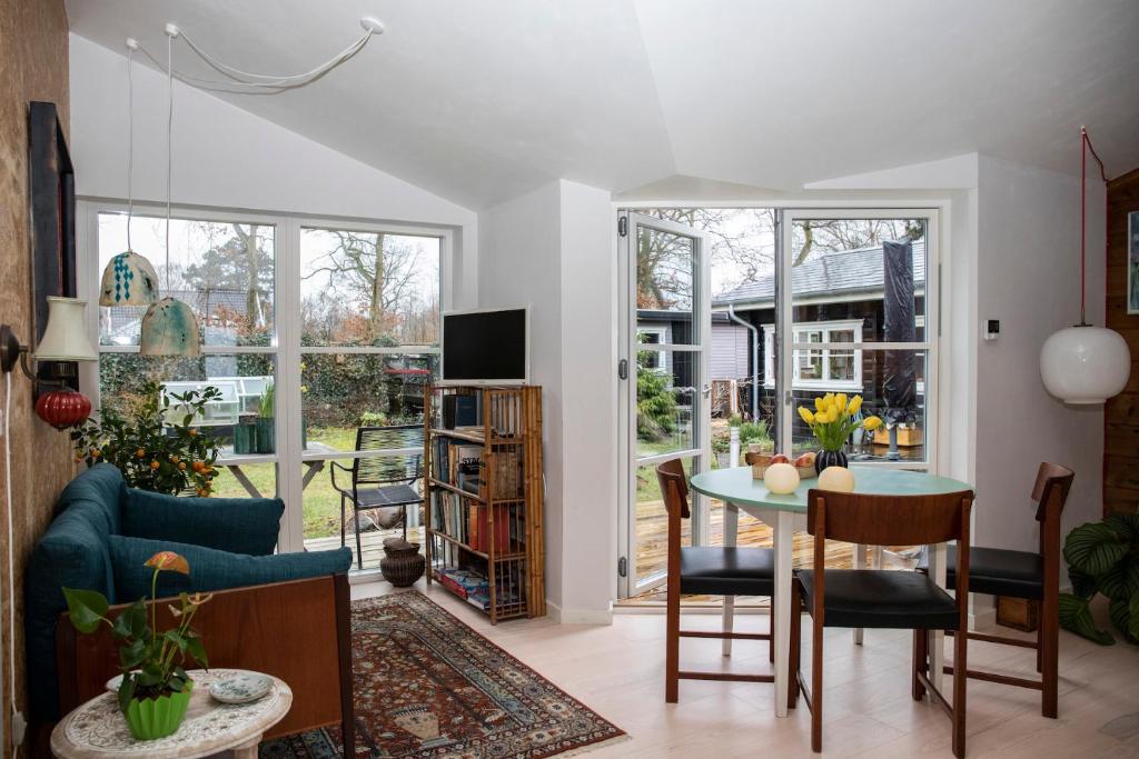 - un salon avec un canapé bleu et une table dans l'établissement Spurvereden ved vandet, à Greve Strand