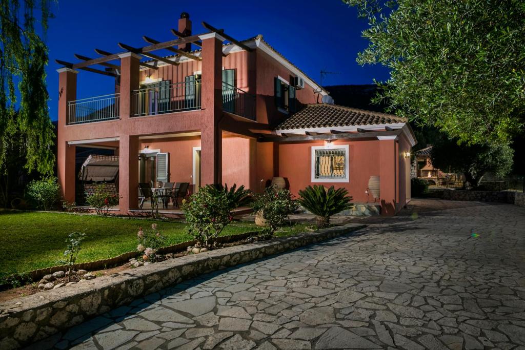 a pink house with a patio and a driveway at VILLA MARITINA in Kefallonia