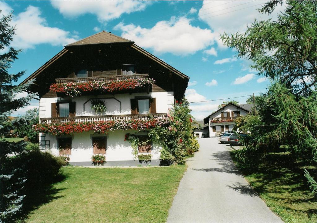una casa con dei fiori sul lato di Kinderbauernhof Wachmann a Rohrbach am Kulm