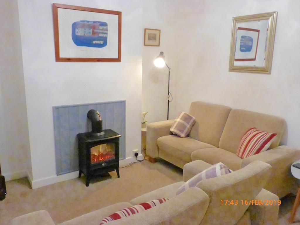 ein Wohnzimmer mit einem Sofa und einem Herd in der Unterkunft Marina Cottage, Newark in Newark upon Trent