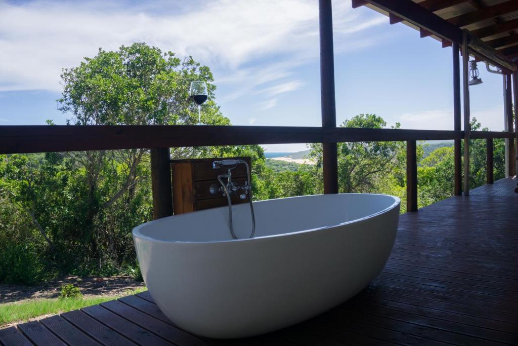 una vasca da bagno situata sulla parte superiore di una terrazza in legno di Maitlands Cottage a Port Elizabeth