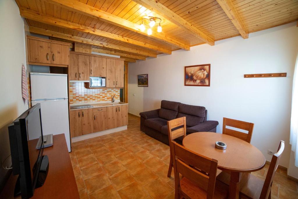 uma cozinha e uma sala de estar com uma mesa e um sofá em Apartamento Olmeda em Alcalá del Júcar