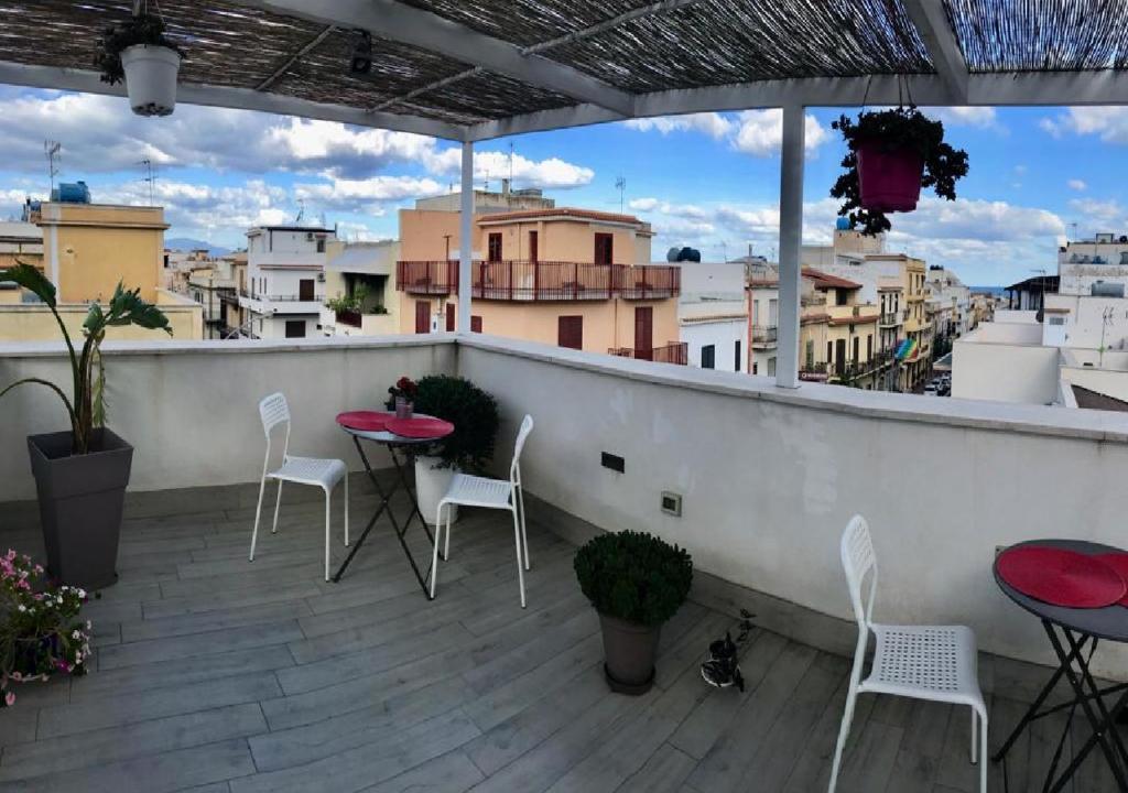 a patio with tables and chairs on a balcony at Alma Nua in Terrasini