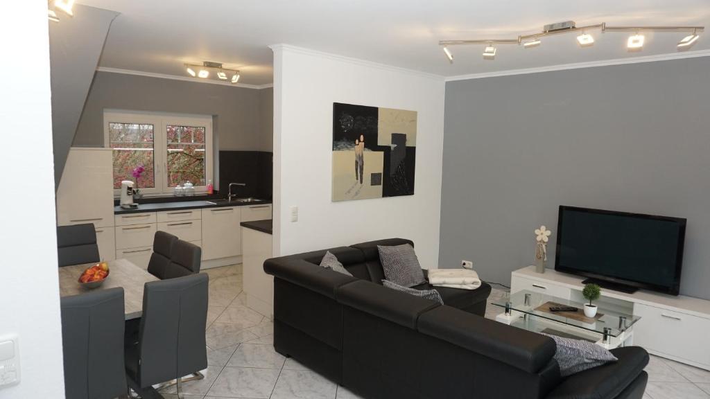 a living room with a couch and a tv at Haus Rodriguez in Baesweiler