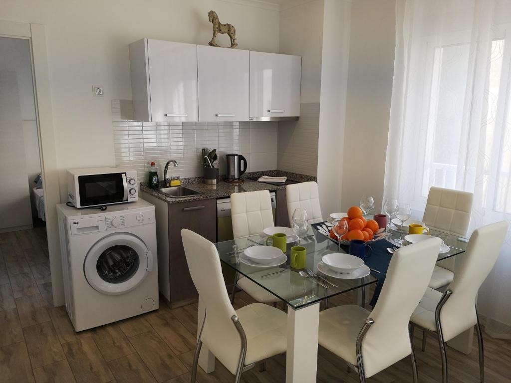 a kitchen with a table with chairs and a dining room at Apartamentos Benidorm Chorrol in Benidorm