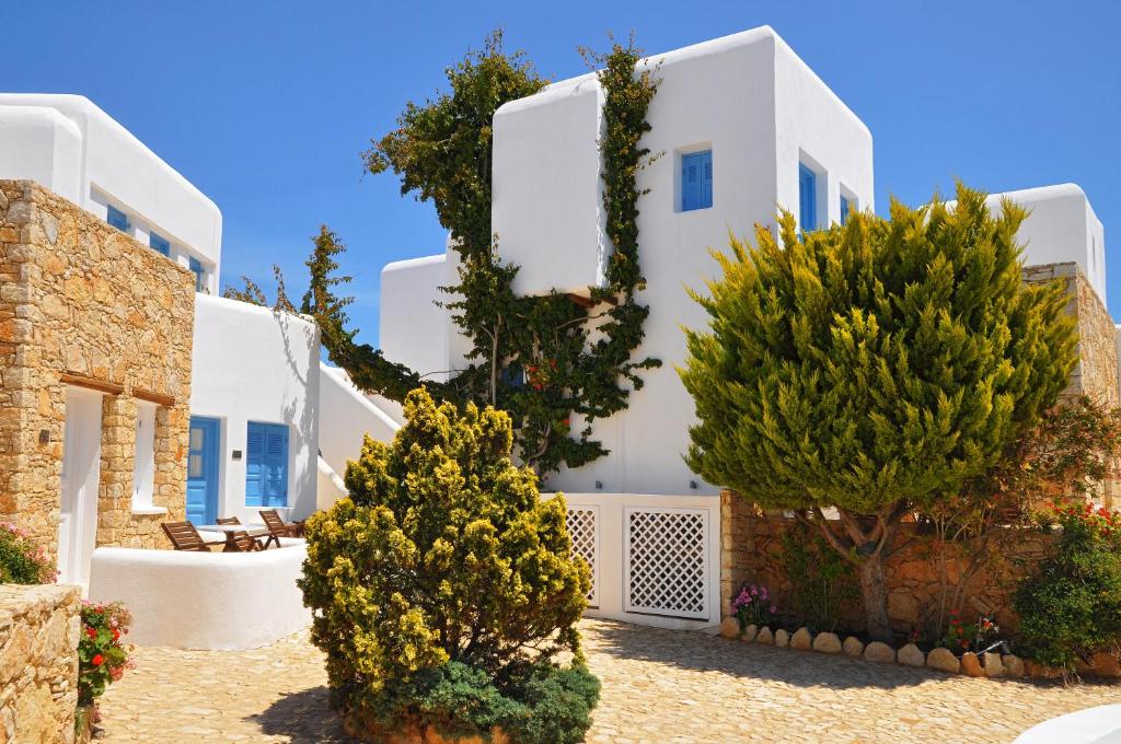a white house with trees in front of it at Chora Resort Hotel & Spa in Chora Folegandros