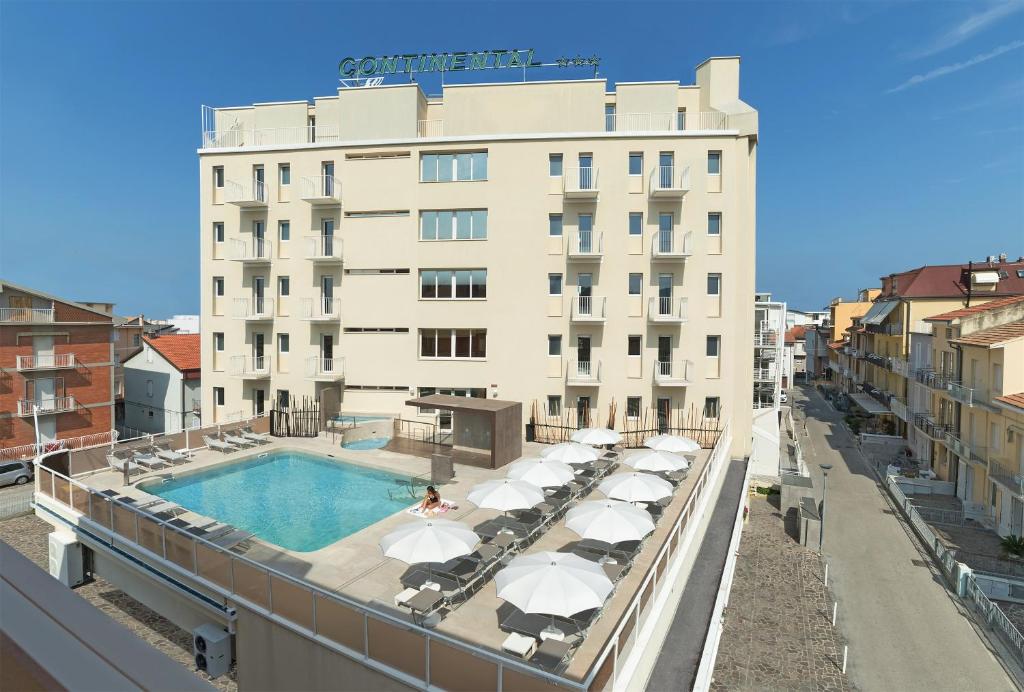 a hotel with a swimming pool and umbrellas at Residence Continental Resort in Gabicce Mare