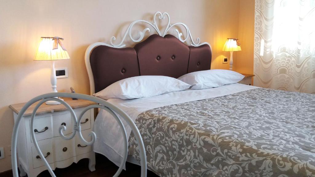 a bedroom with a bed and a dresser with two lamps at Villa Bruna in Cesenatico