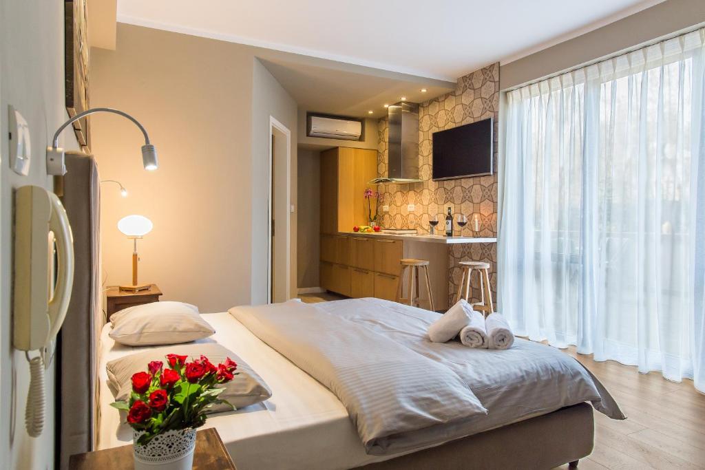 a bedroom with a large bed and a kitchen at One Love Metropolitan Gardens Studio II in Bucharest