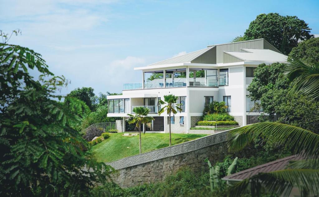 維多利亞的住宿－AquaBlu Villa，一座树木茂密的山丘上的白色大房子