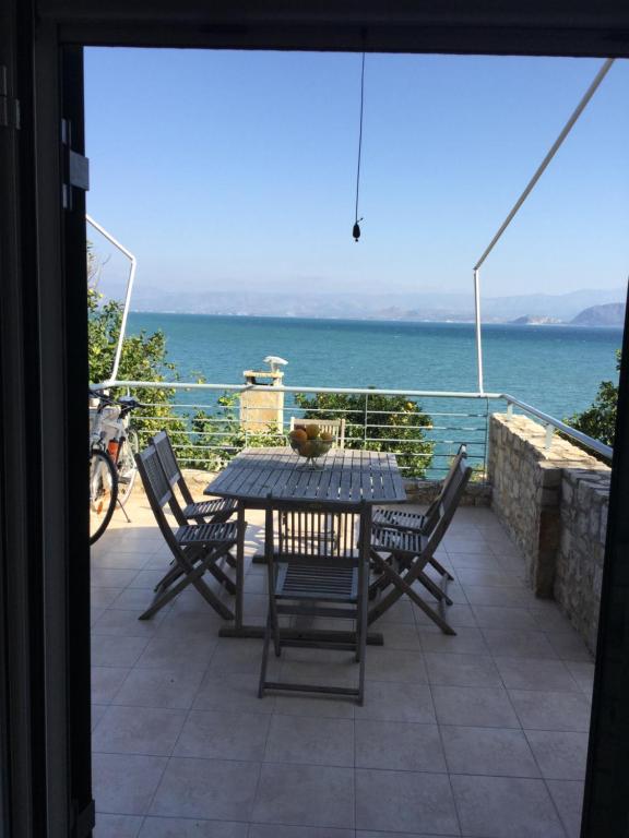 a table and chairs on a patio with a view of the ocean at Seafront apartment ΙΙ in Kiveri, near Nafplion. in Kiveri