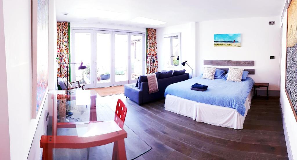 ein Schlafzimmer mit einem blauen Bett und einem Sofa in der Unterkunft Lake Street Studios in Oxford