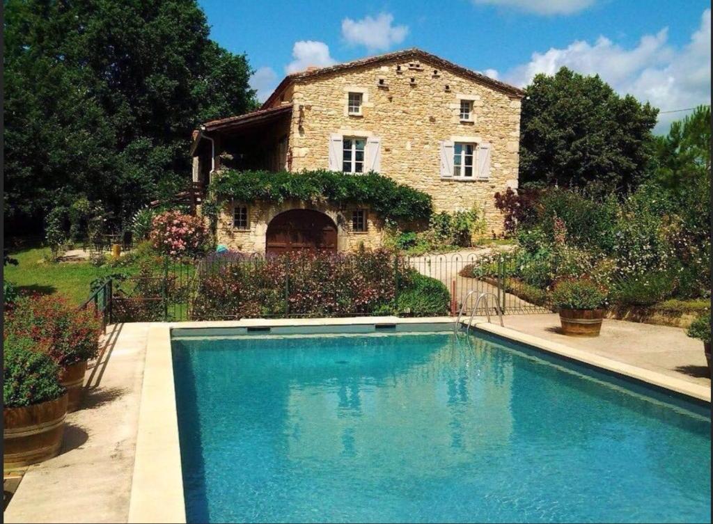 uma casa com piscina em frente a um edifício em Petite Vue Vert em Roubert