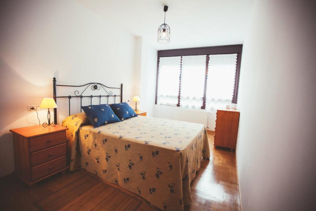 um quarto com uma cama, uma cómoda e 2 janelas em Espumeru, apartamento en Llanes em Llanes