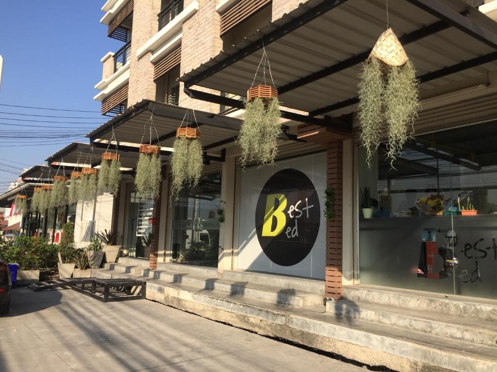 un restaurante de comida rápida con plantas colgando del edificio en Best Bed Suvarnabhumi Hostel, en Lat Krabang