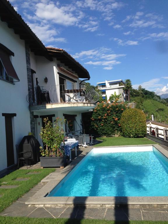 a swimming pool in front of a house at Casa Micheroli Parterre in Gordola