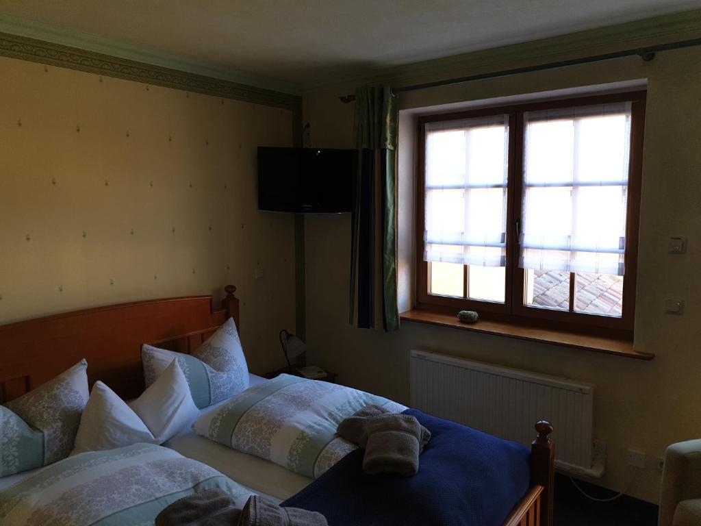 a bedroom with two beds and a window at Hotel Piccolo in Schleiz