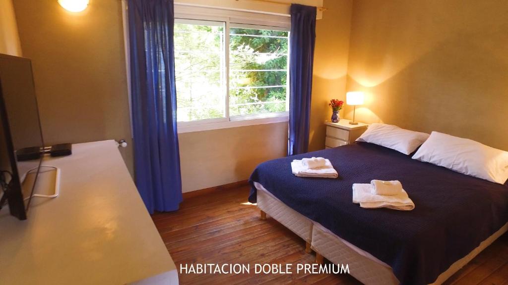 a bedroom with a bed and a window with towels on it at Hosteria Sirena in Valeria del Mar