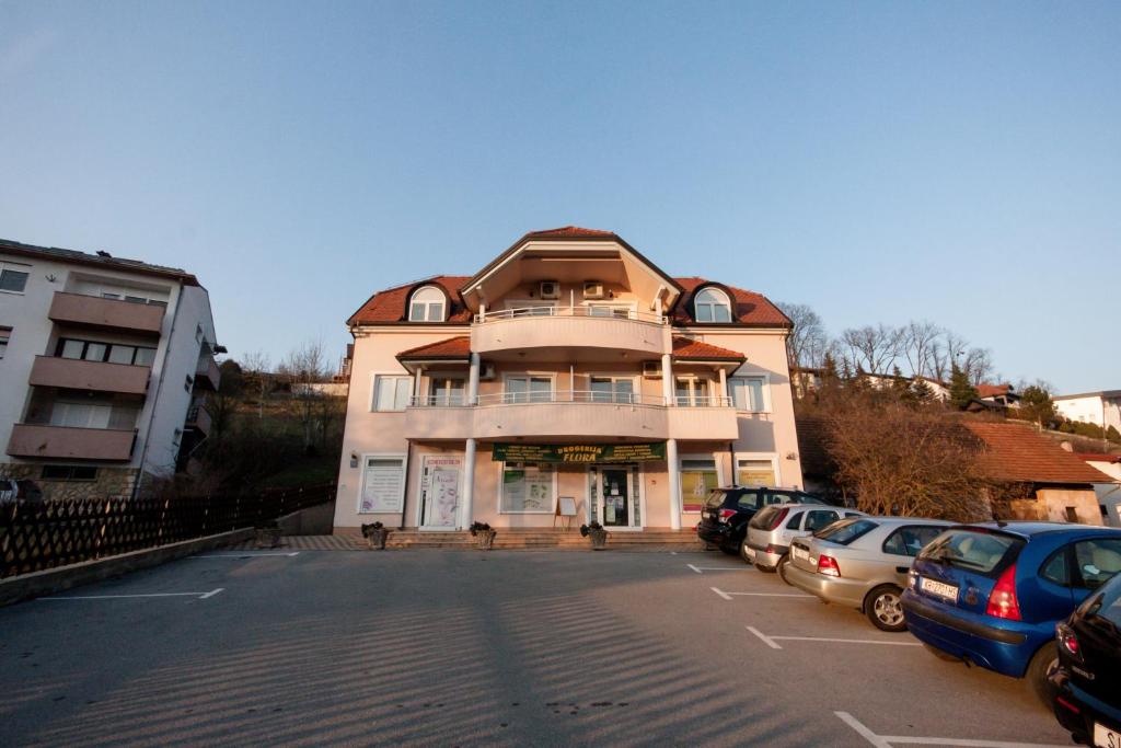 a large building with cars parked in a parking lot at Apartmani Strsoglavec in Krapinske Toplice