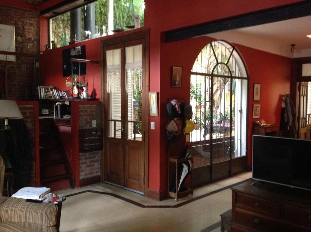 una sala de estar con paredes rojas y puertas de cristal. en Corazón de Palermo Soho en Buenos Aires