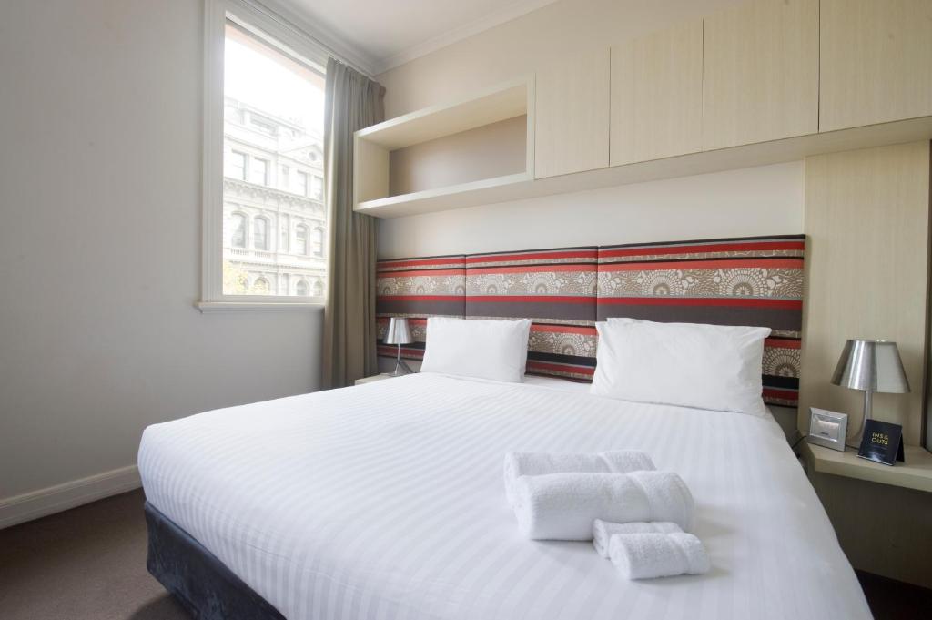 a bedroom with a large white bed with two towels on it at Best Western Melbourne City in Melbourne