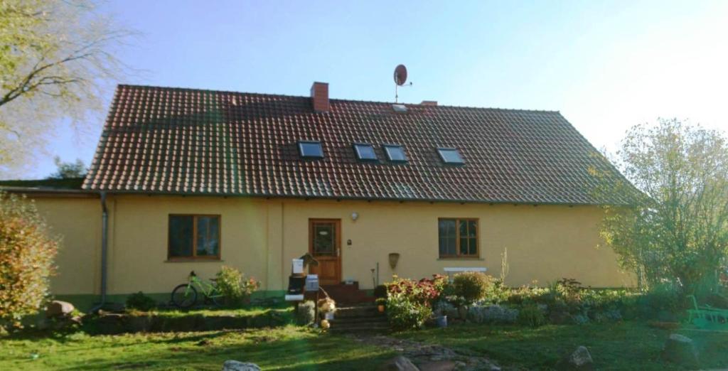 une grande maison jaune avec un toit rouge dans l'établissement Reiterhof Groß Stubben, à Poseritz