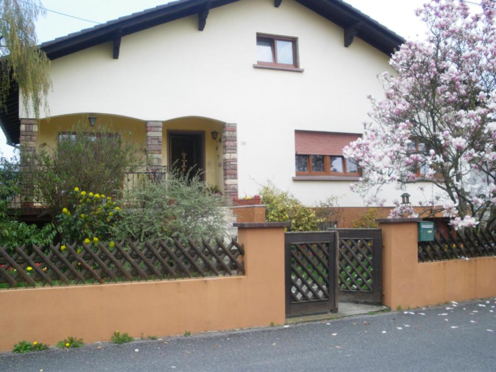 una casa con una valla y un árbol florido en Gîte du Frankenbourg, en Châtenois