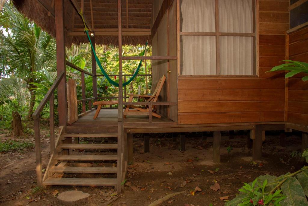 a porch of a house with a green hose at Tambopata River in Puerto Maldonado
