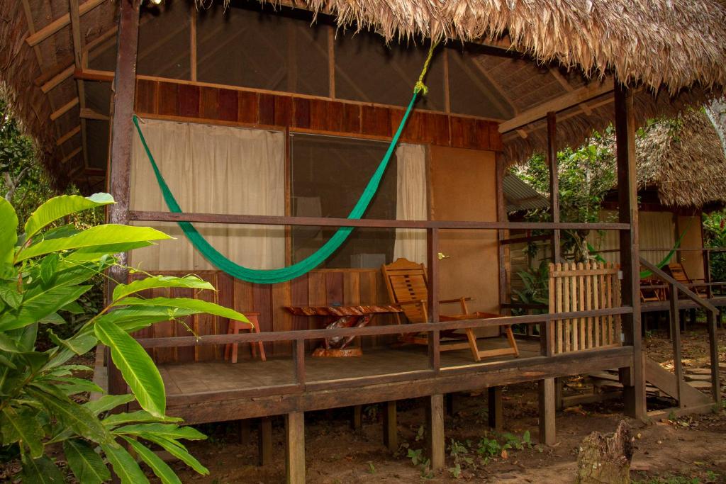 a small hut with a hammock in front of it at Tambopata River in Puerto Maldonado