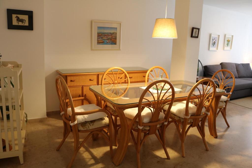 a dining table and chairs in a living room at Apartamento moderno en el centro de moraira in Moraira