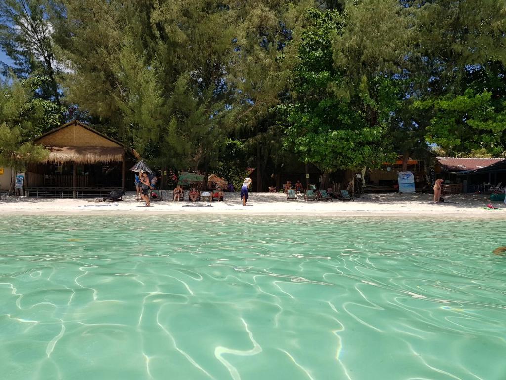 ein Wasserkörper mit Strand und Bäumen im Hintergrund in der Unterkunft Green View Beach Resort in Ko Lipe