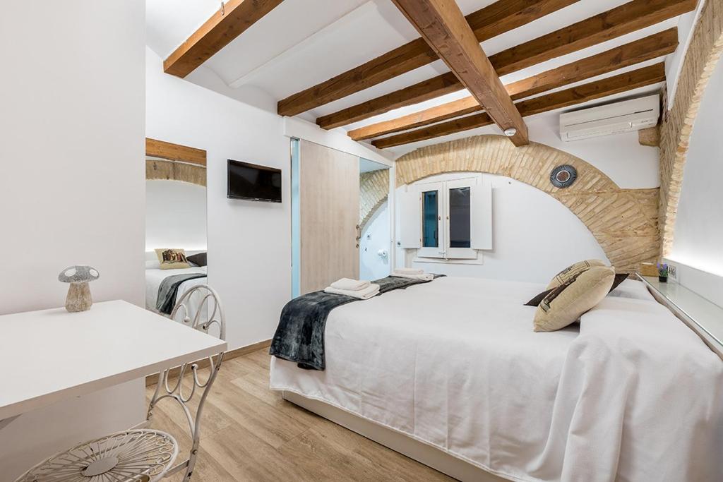 タラゴナにあるHostal 977のベッドルーム(白い大型ベッド1台、デスク付)