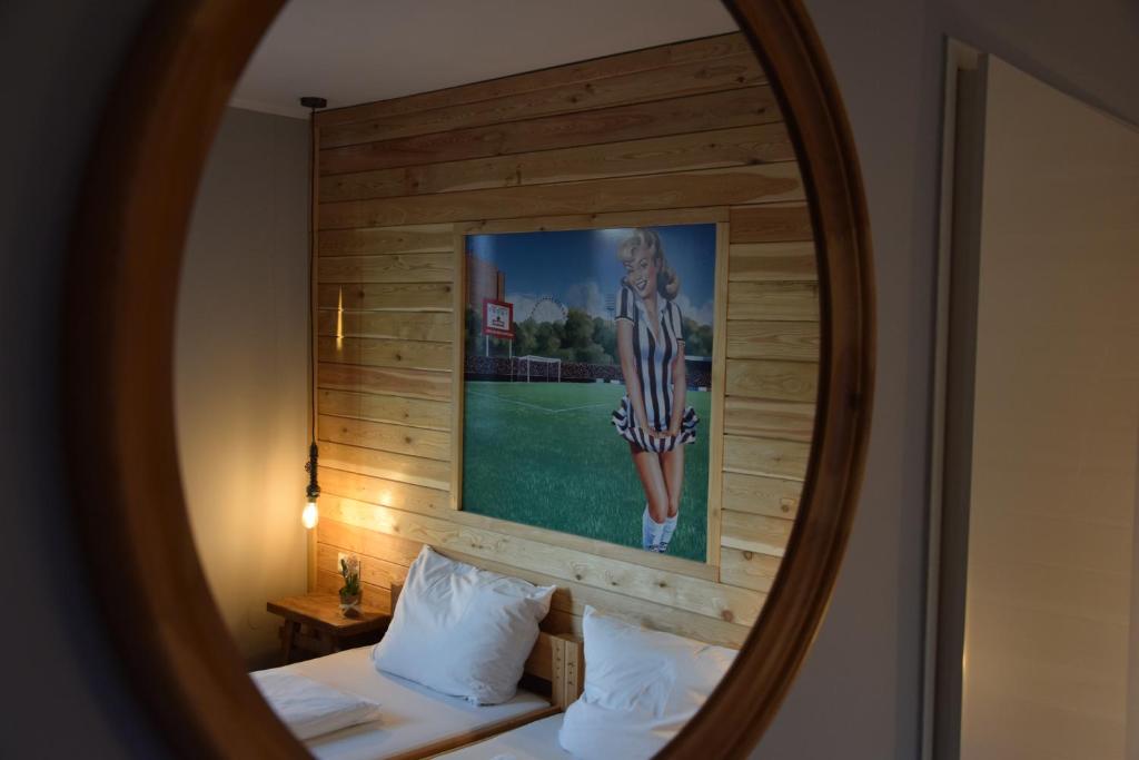 a mirror reflecting a bed with a picture on the wall at Hamburger Alm Hotel St. Pauli in Hamburg