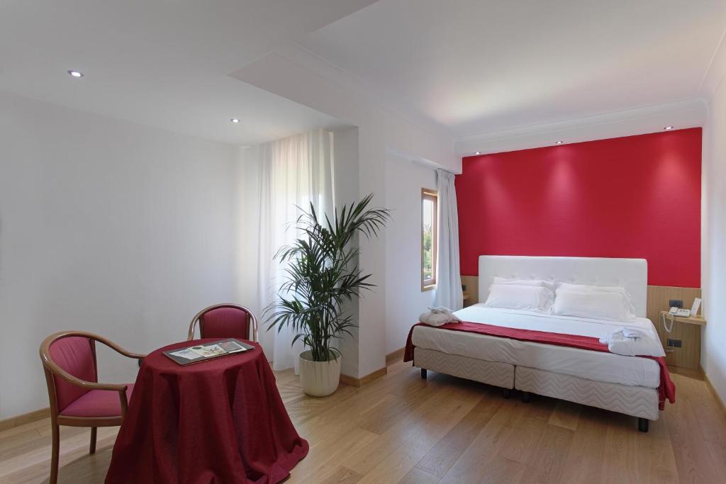 1 dormitorio con cama y pared roja en Hotel Della Valle en Agrigento