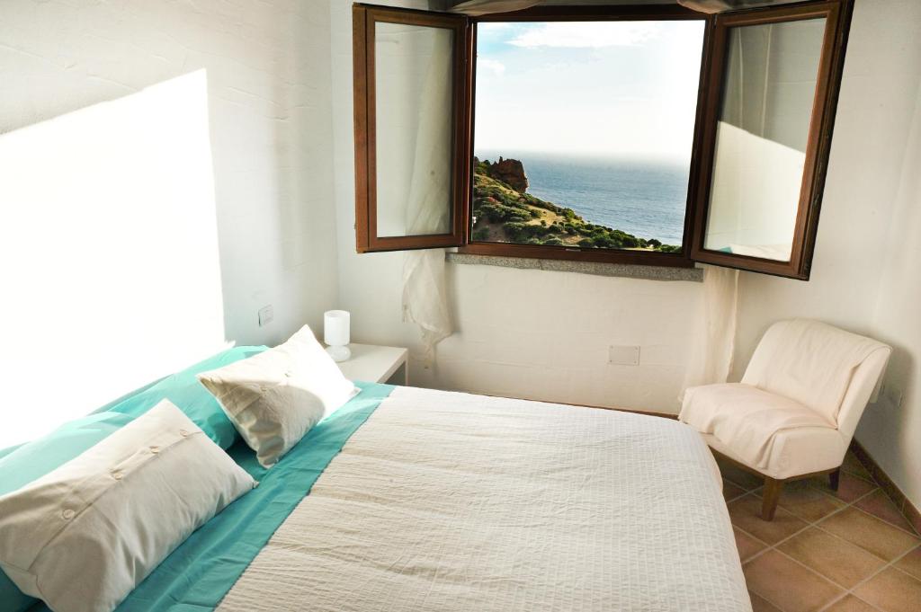 um quarto com uma cama com uma janela e uma cadeira em Arromaniu em Nebida