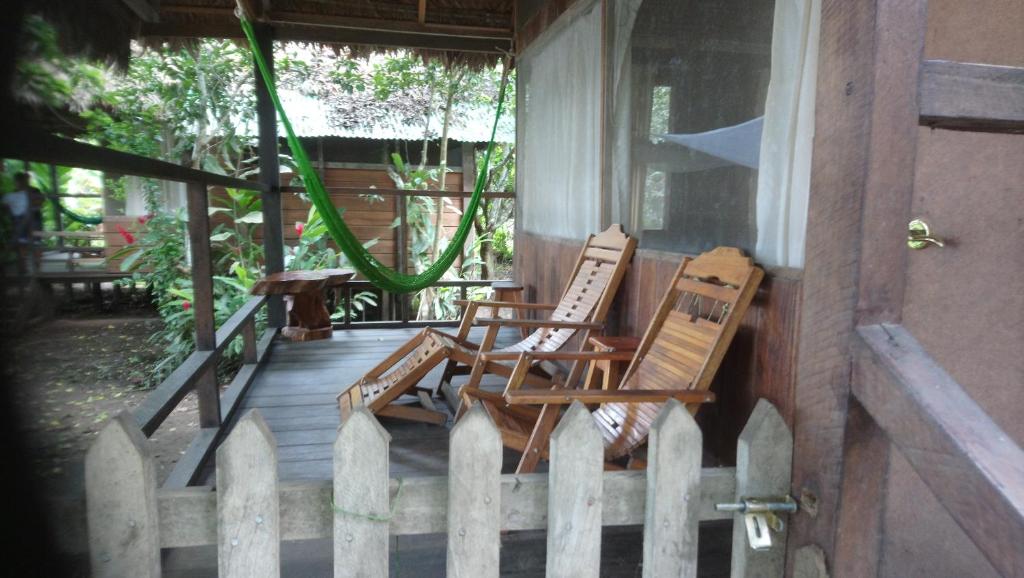 two chairs sitting on a porch with a fence at Tambopata River in Puerto Maldonado